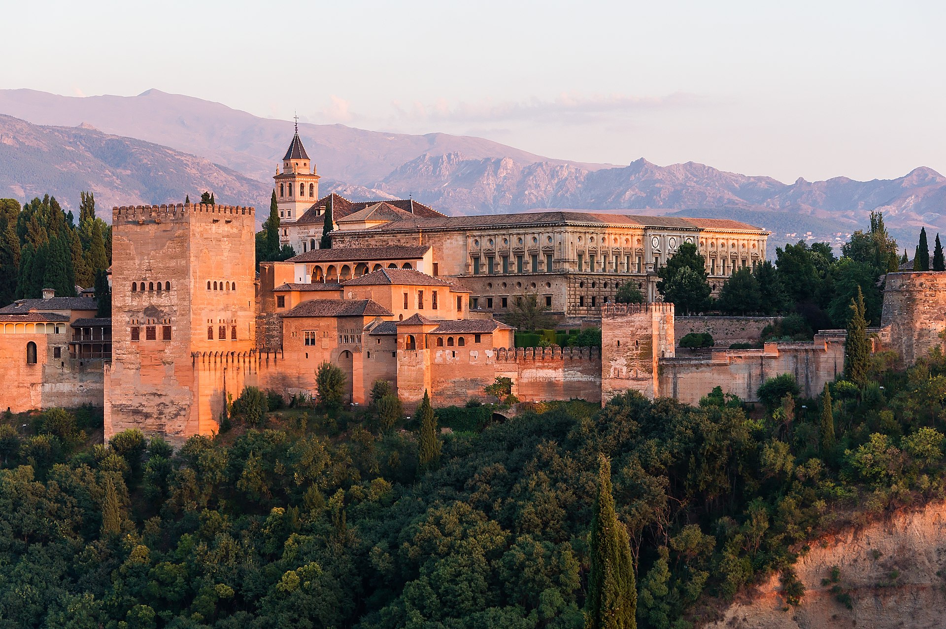 The Alhambra palace reflected in a pool at sunset